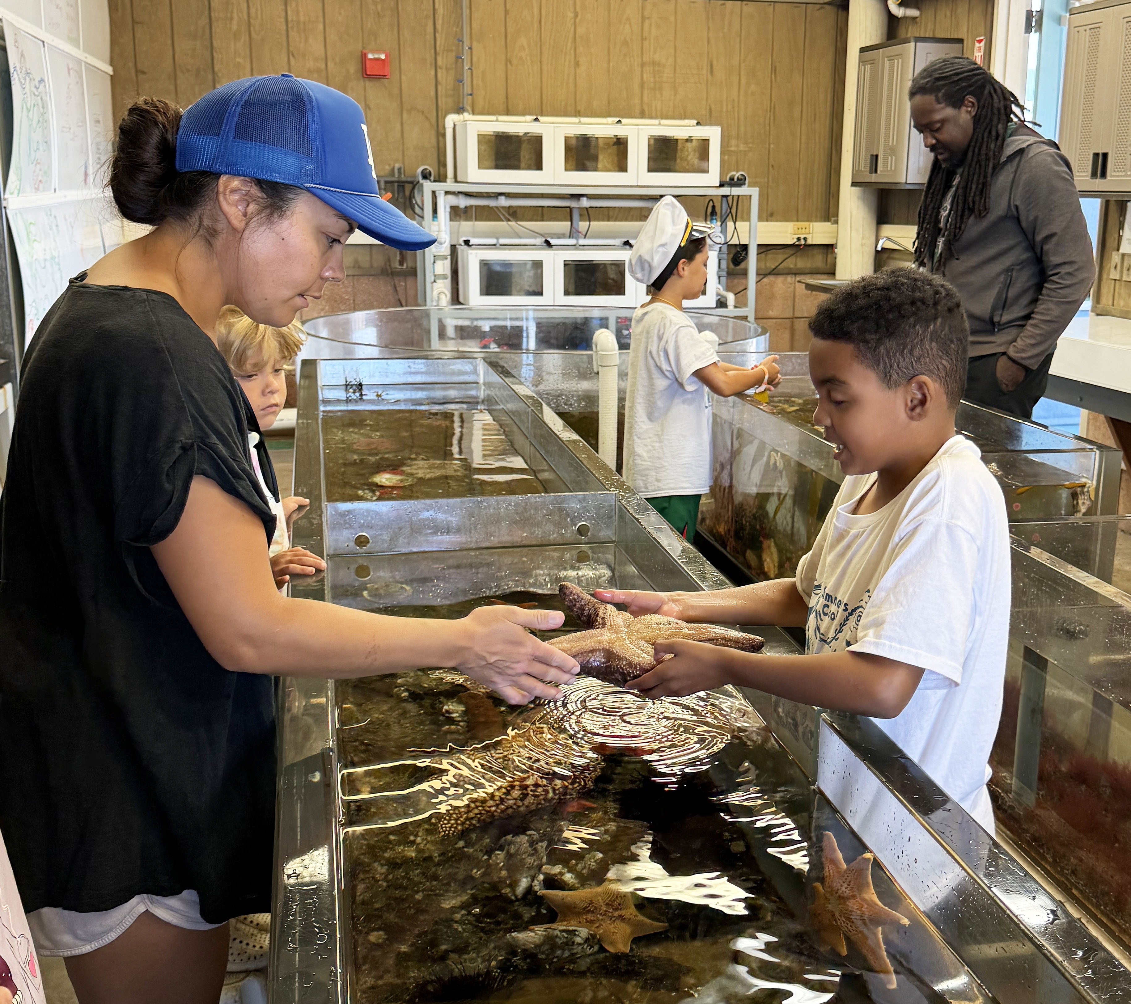 Camper shows seastar to a parent at the REEF