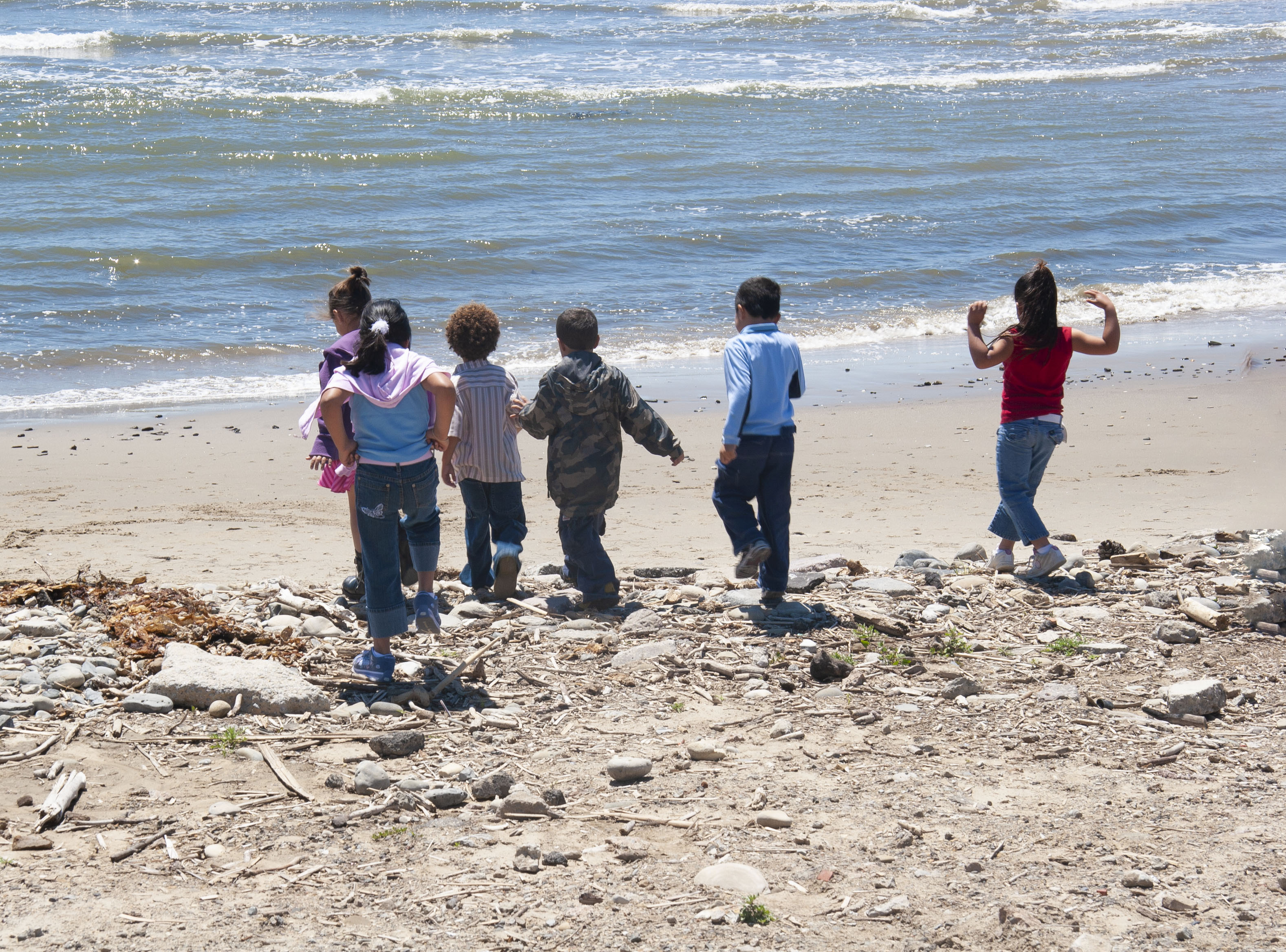 Grade school kids run toward the ocean at Capus Point