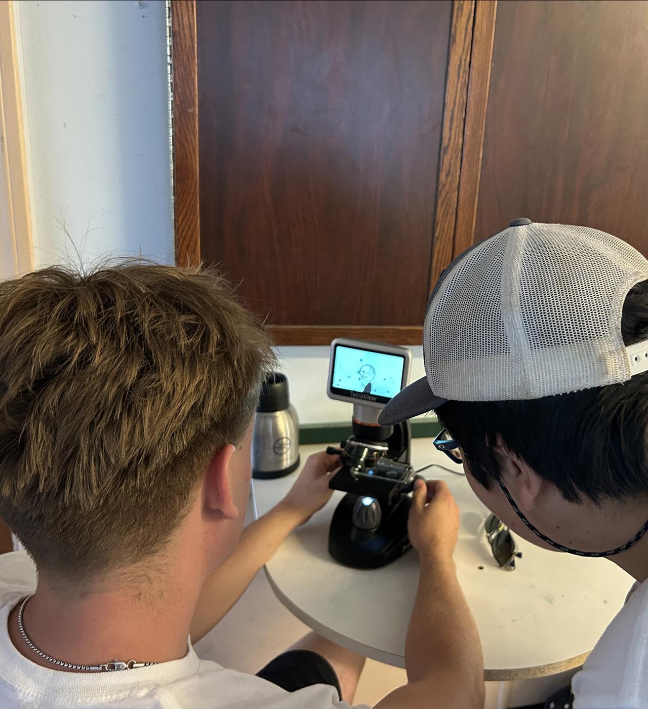UCSB undergrad and REEF camper looking at instrumentation on desk 